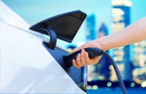 Person charging an electric vehicle